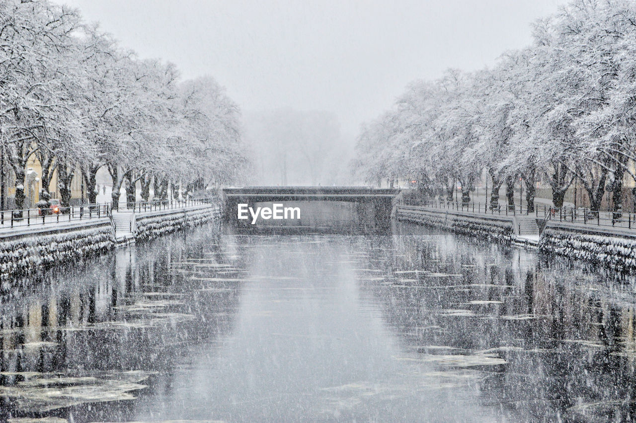 Bridge over river during snowfall 