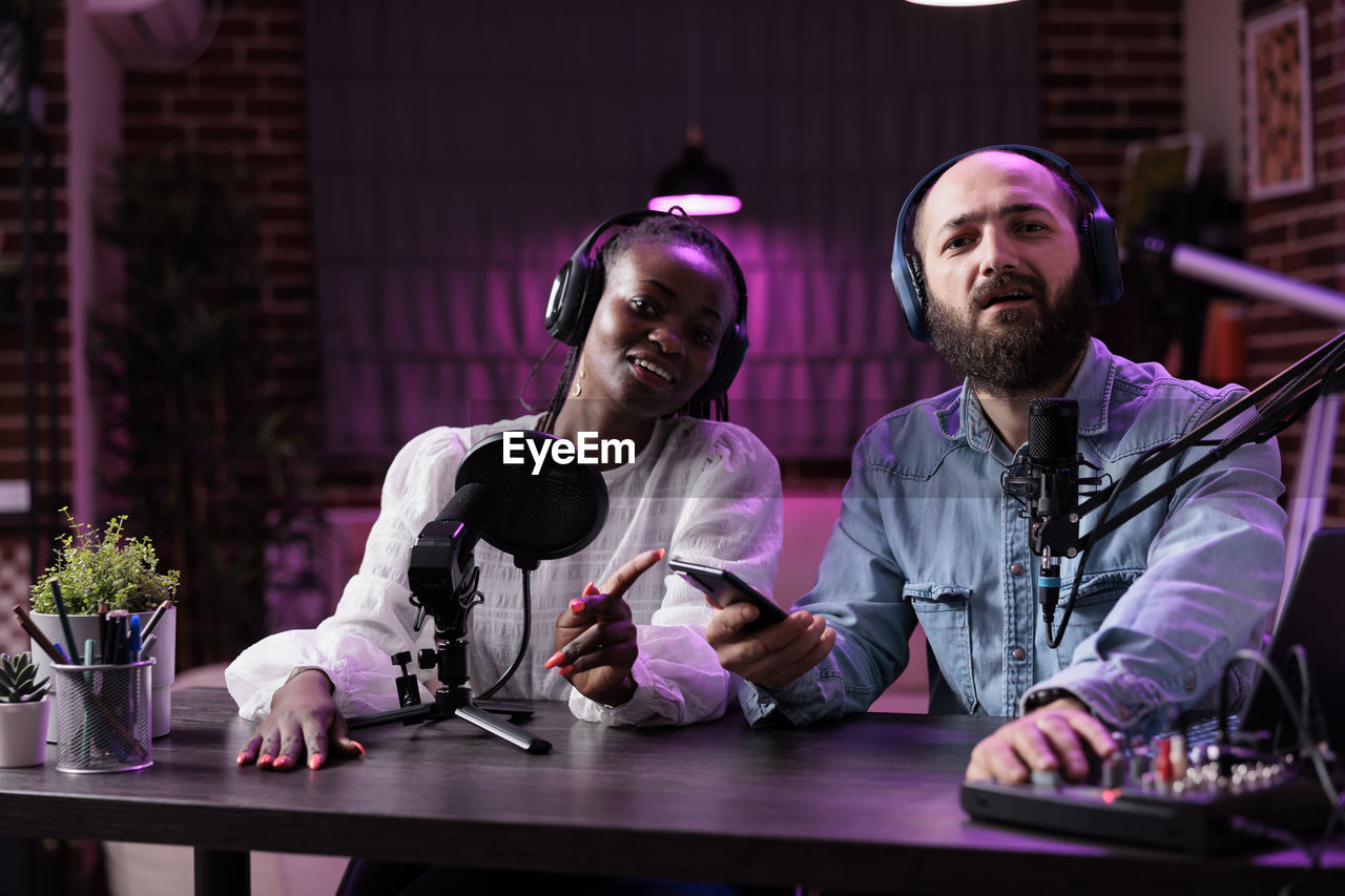 Portrait of vloggers sitting at studio