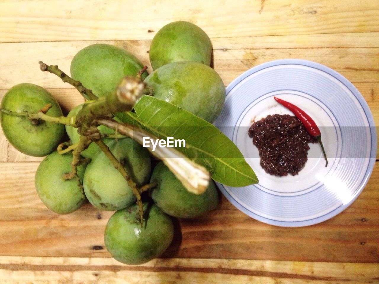 Directly above shot of mangoes with pickle and chili on table