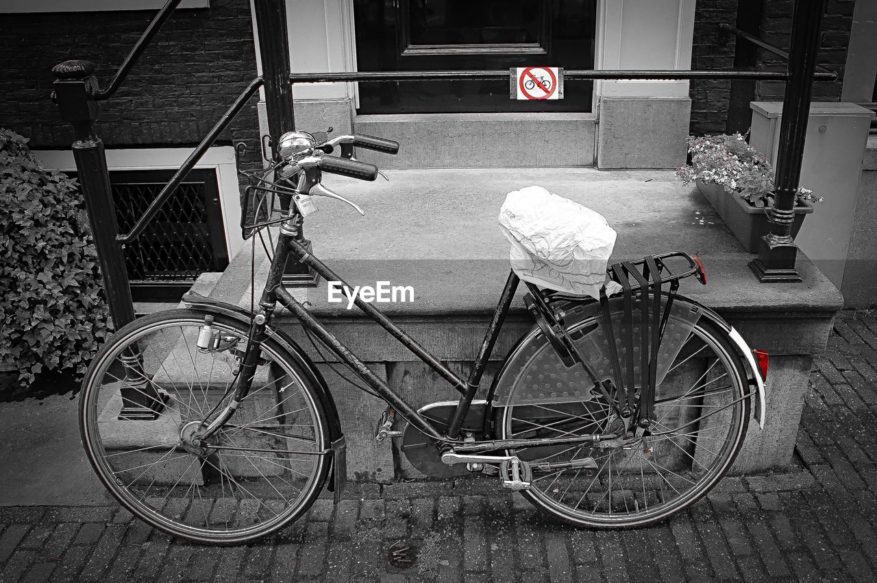 Side view of bicycle parked against wall