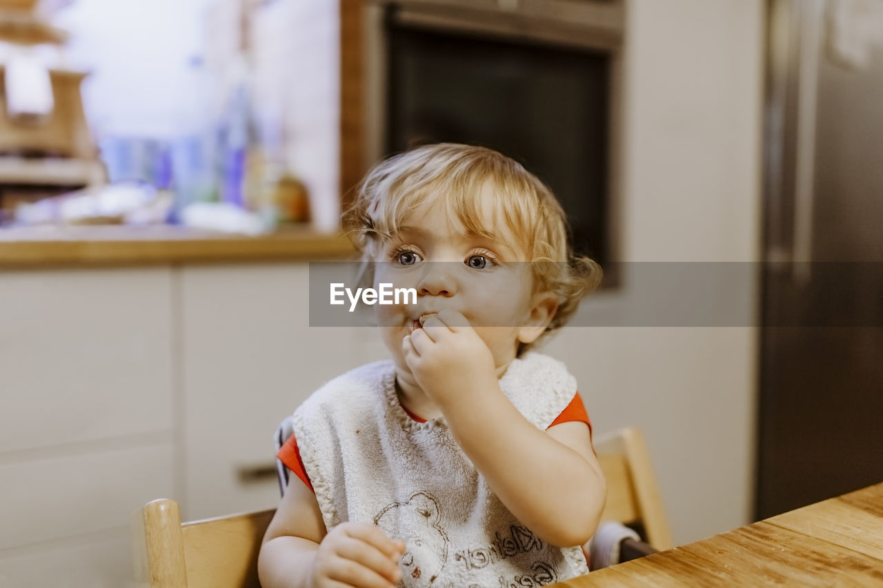 Cute girl eating food at home
