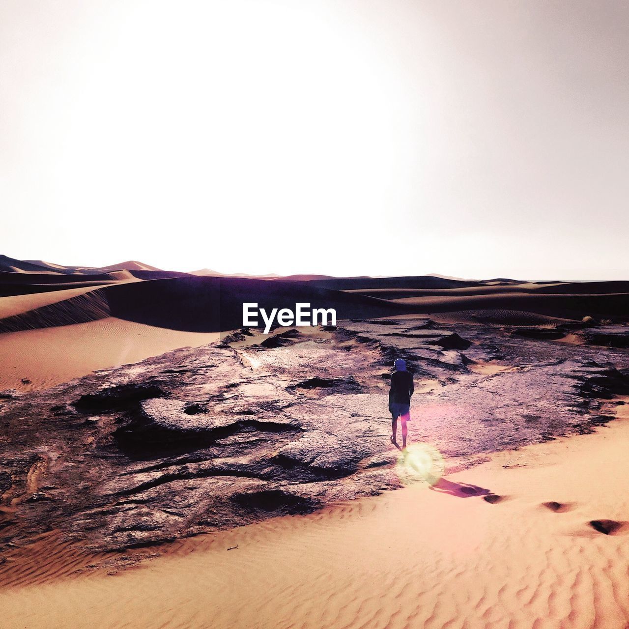 REAR VIEW OF WOMAN ON SAND DUNE