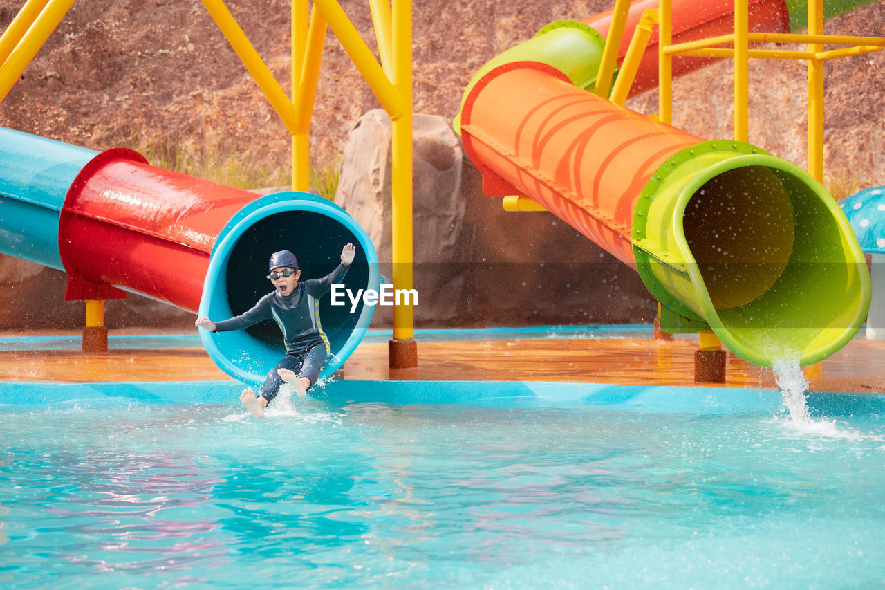 BOY PLAYING AT SWIMMING POOL