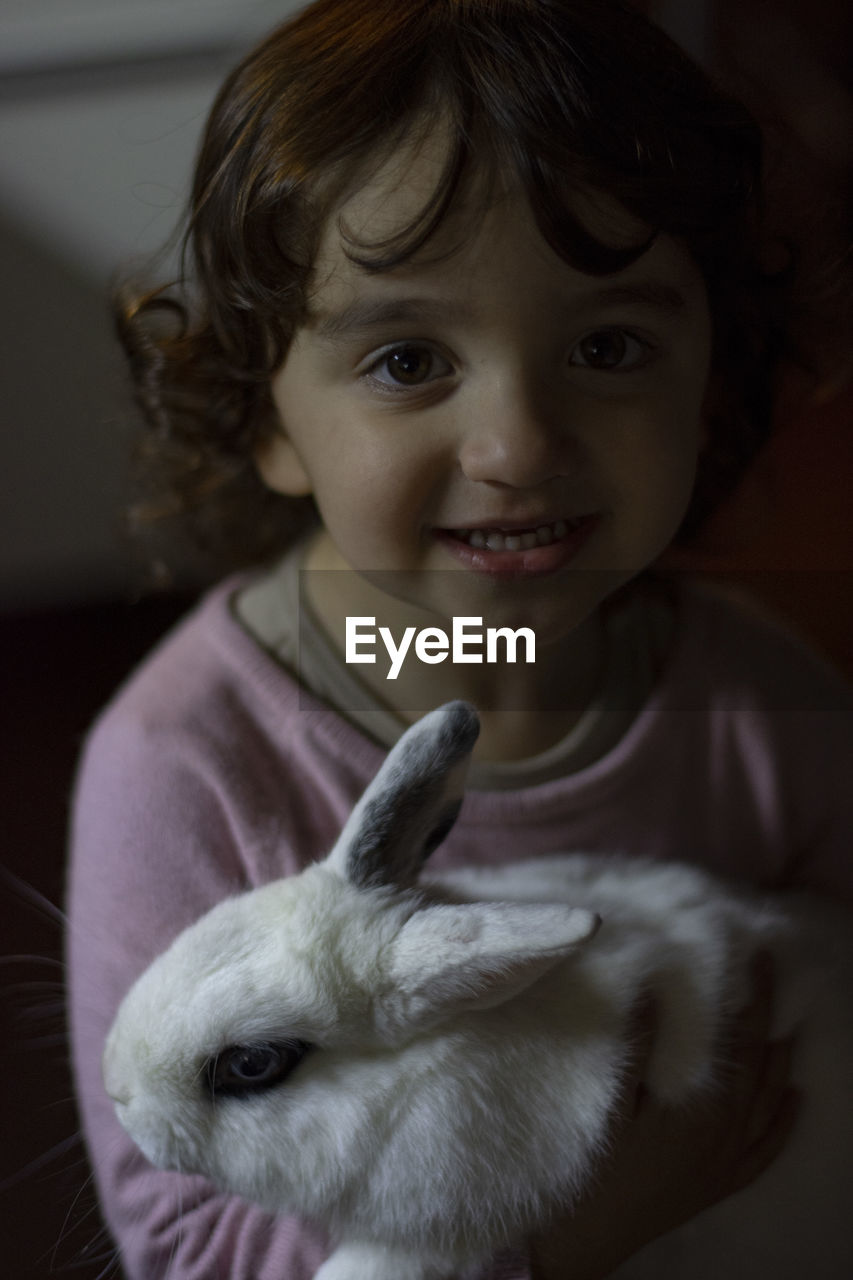 Portrait of cute girl with a white rabbit