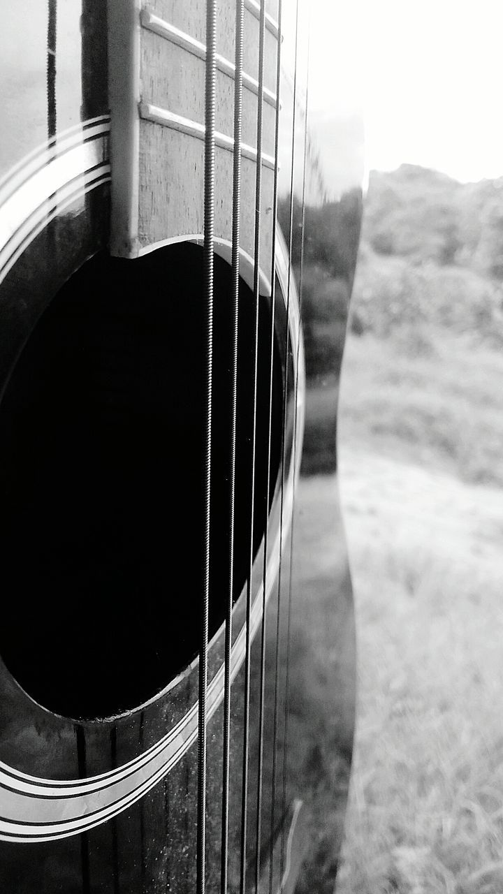 CLOSE-UP OF GUITAR AGAINST THE SKY