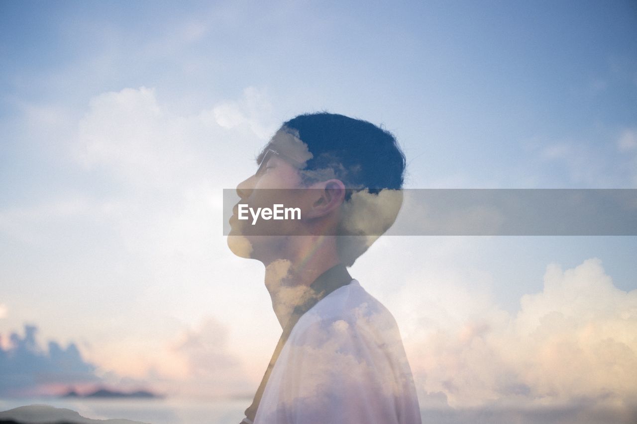Double exposure of man and clouds