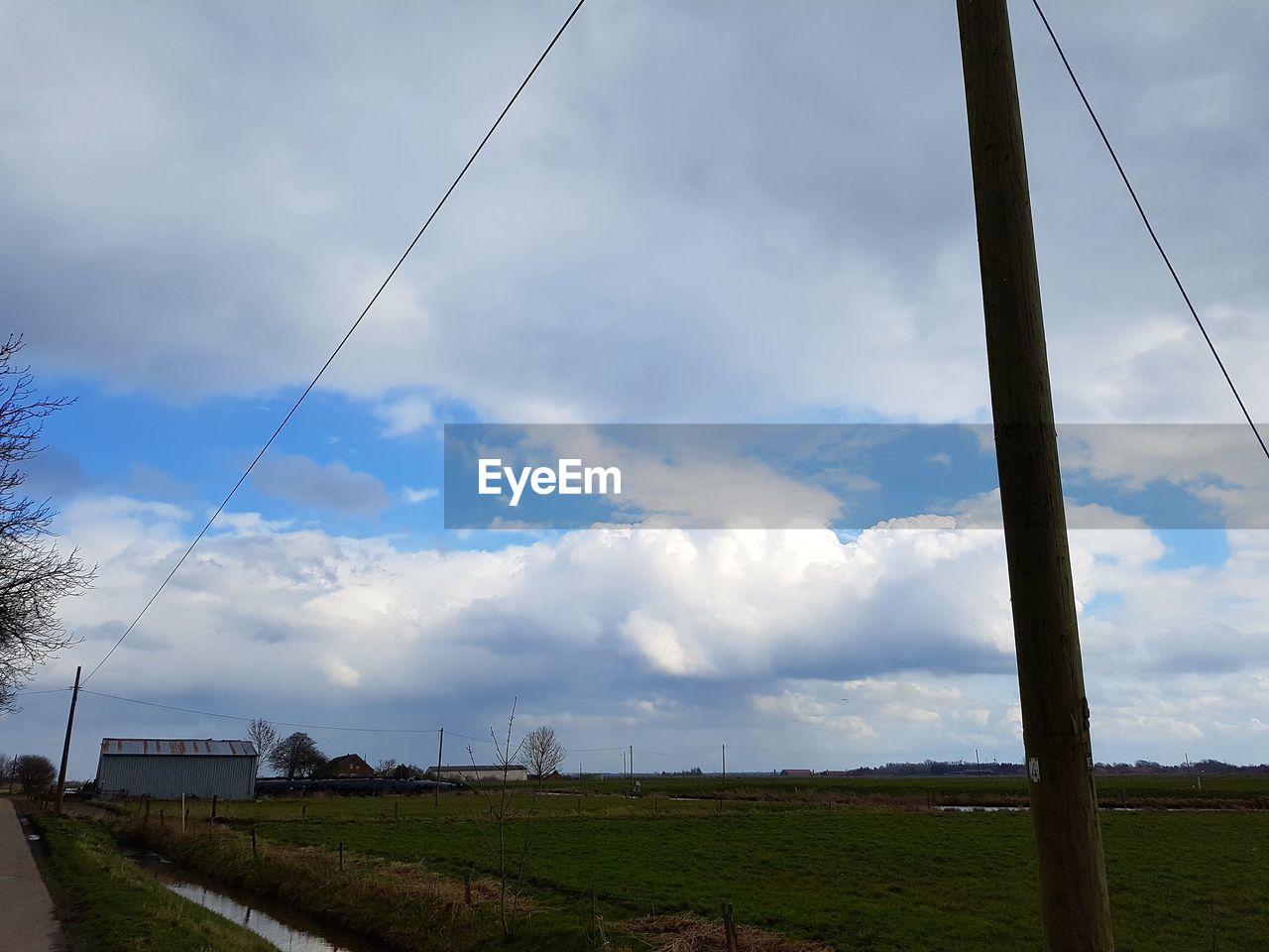 VIEW OF FIELD AGAINST CLOUDY SKY