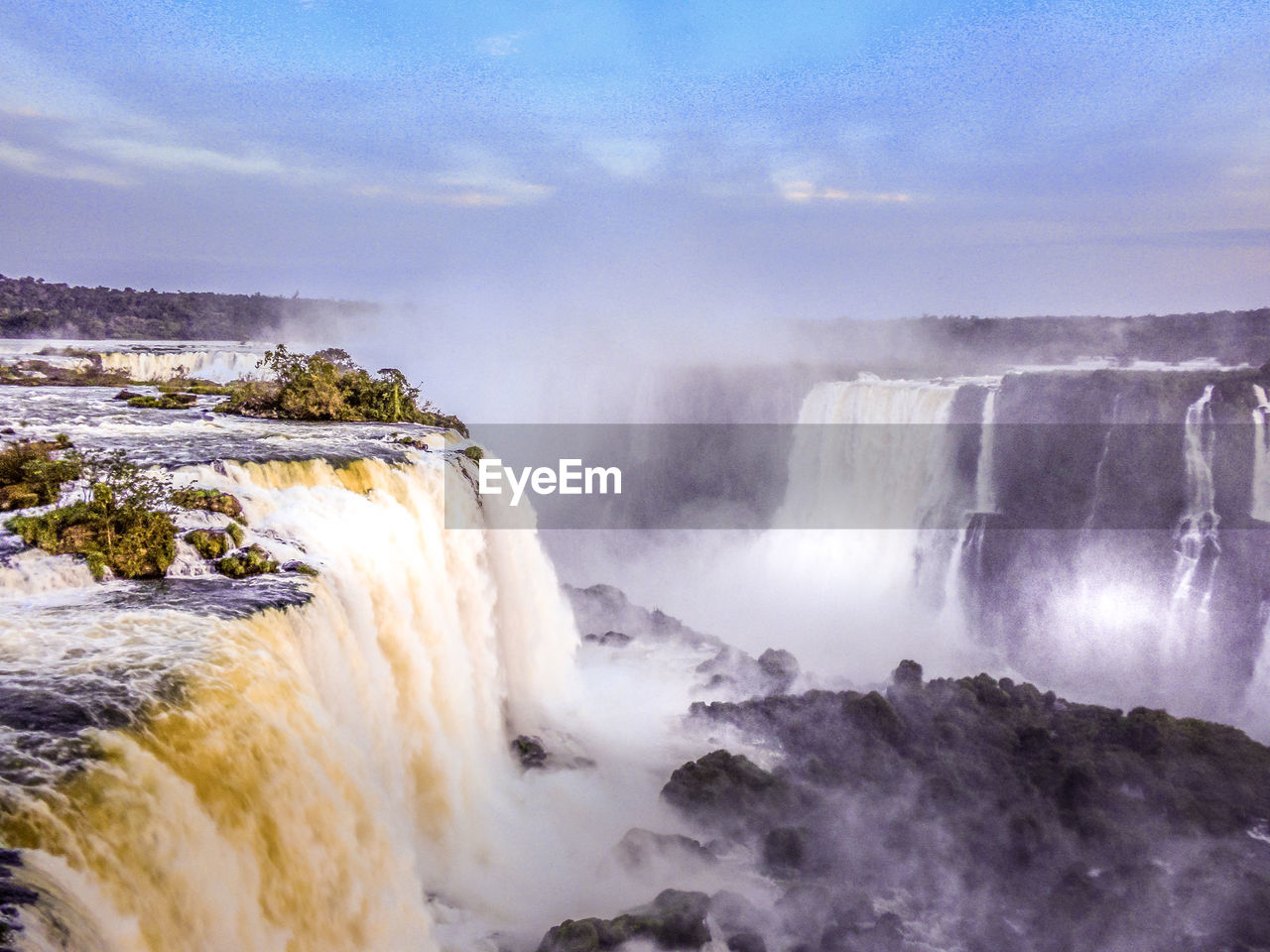 Scenic view of waterfall in sea against sky