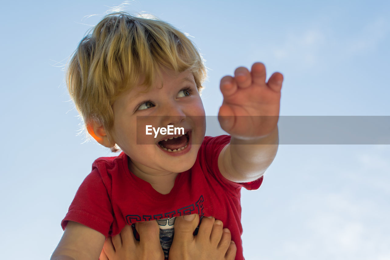 Portrait of smiling boy against sky