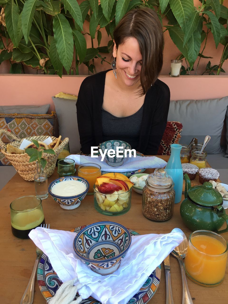 High angle view of smiling young woman looking at meal served on table