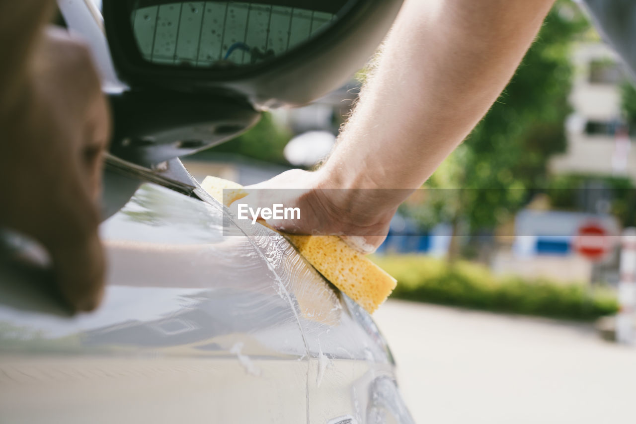 Cropped hands washing car