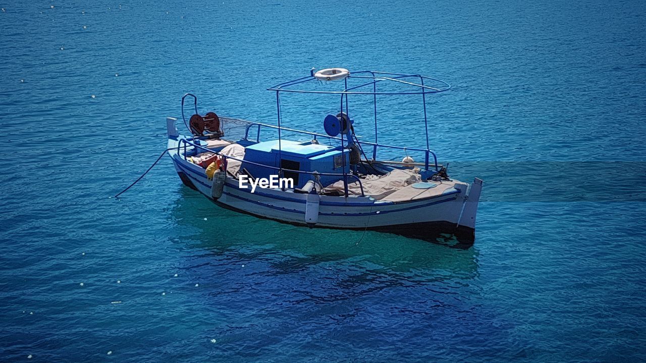 HIGH ANGLE VIEW OF BOATS MOORED IN SEA