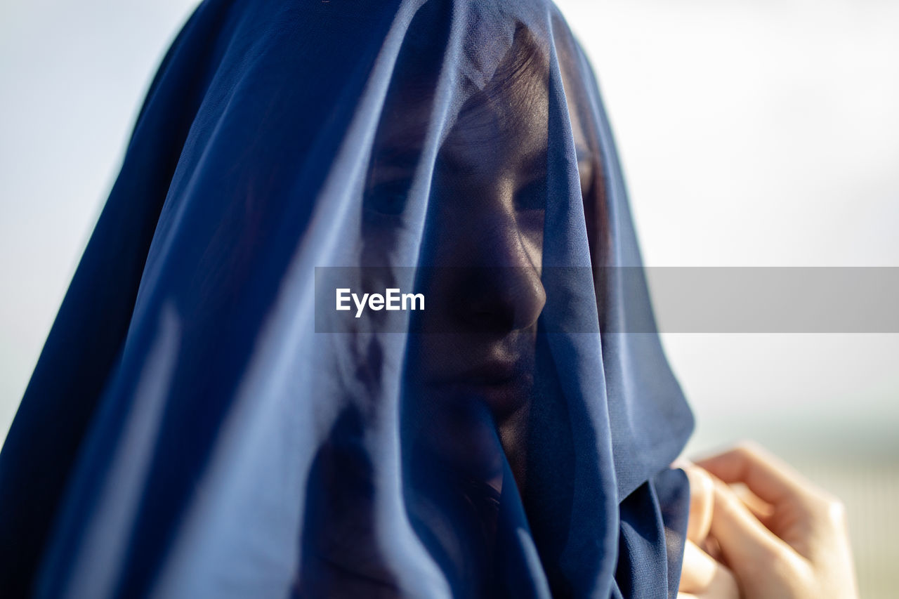 Close-up of woman covered with navy blue textile