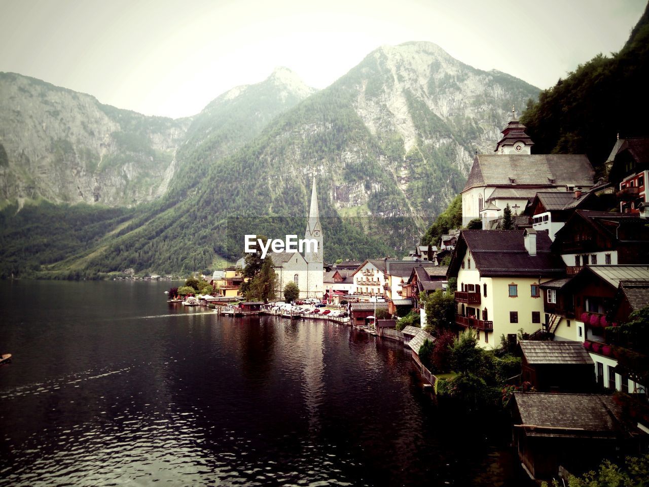 PANORAMIC VIEW OF TOWNSCAPE BY LAKE AGAINST BUILDINGS