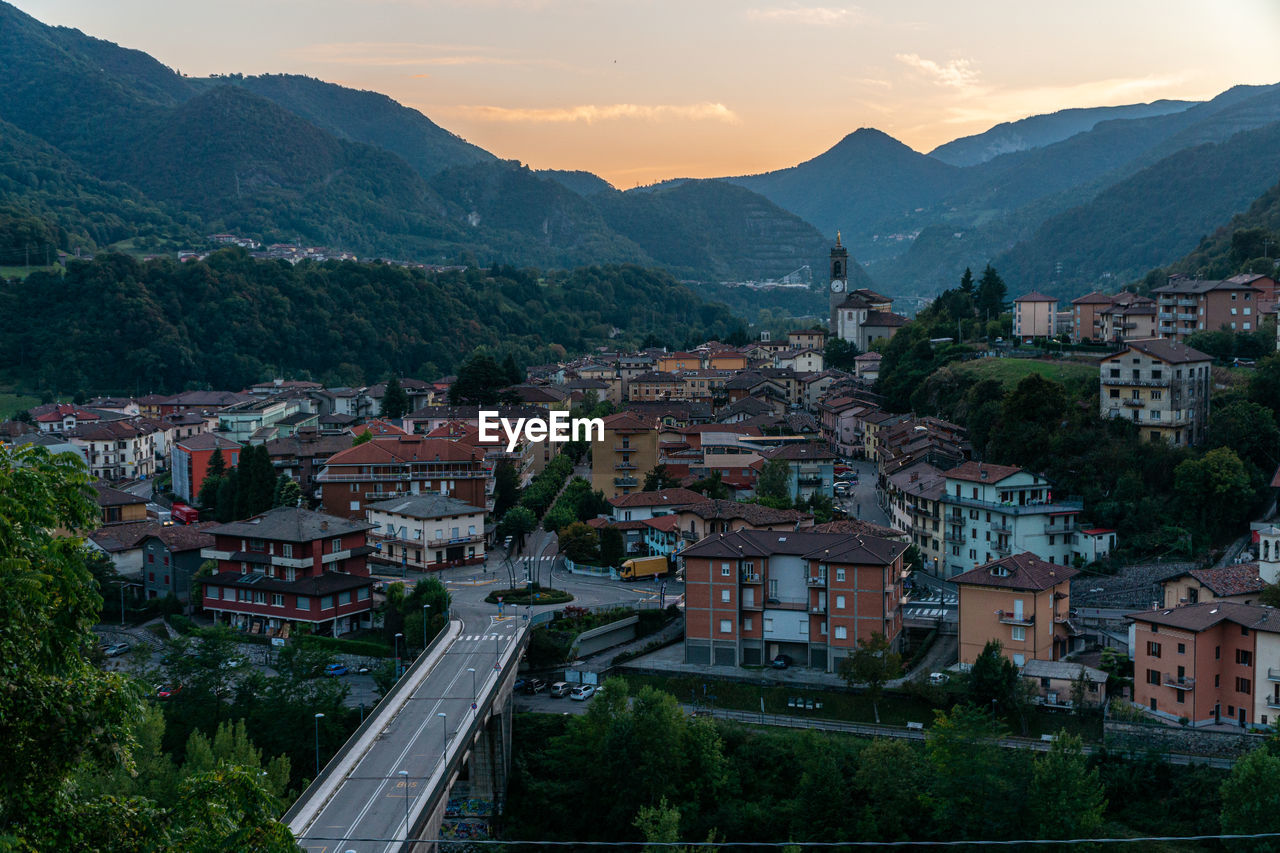 High angle view of townscape by mountain against sky in italy, zogno