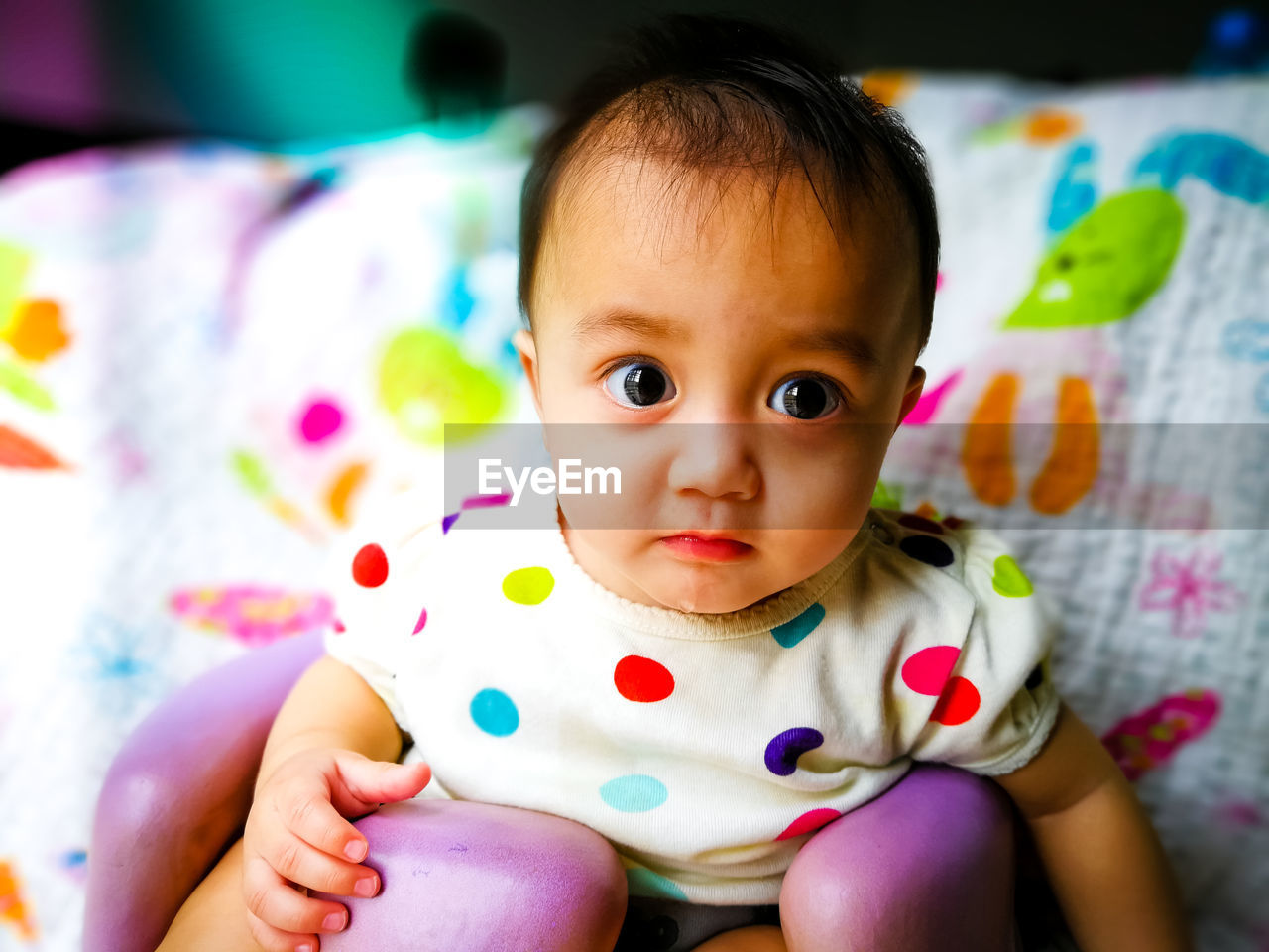 Close-up portrait of cute baby girl drooling at home