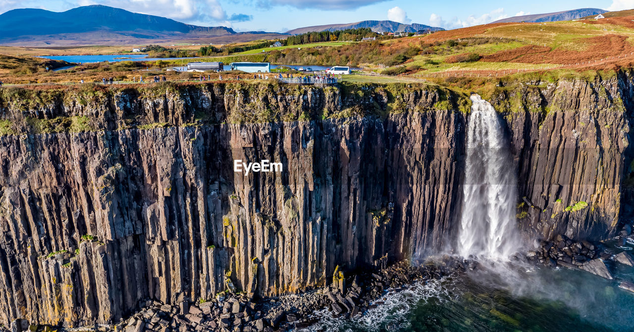 SCENIC VIEW OF WATERFALL IN MOUNTAINS