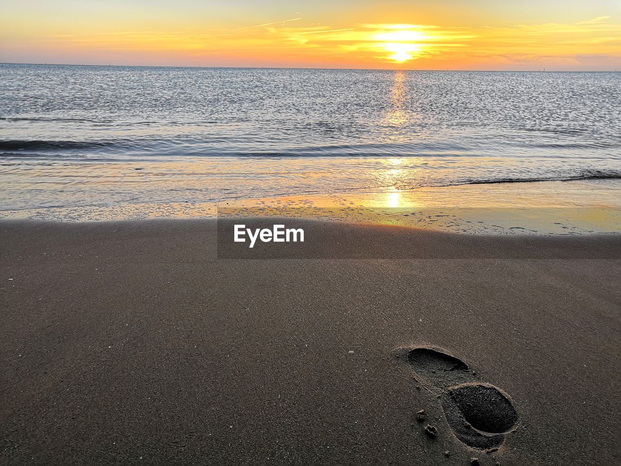 SCENIC VIEW OF BEACH AGAINST SKY DURING SUNSET