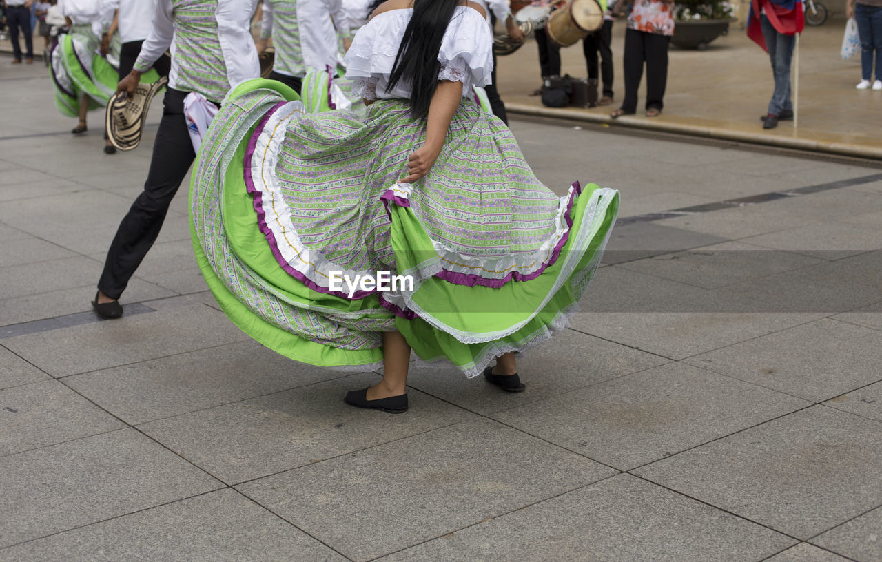 Low section of people dancing on footpath