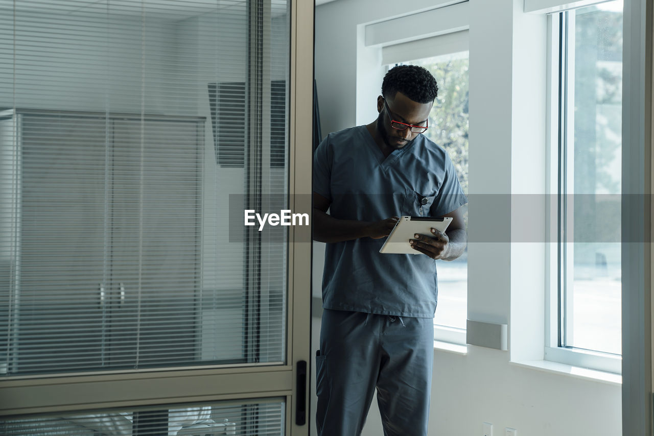 Doctor using tablet computer while working in hospital