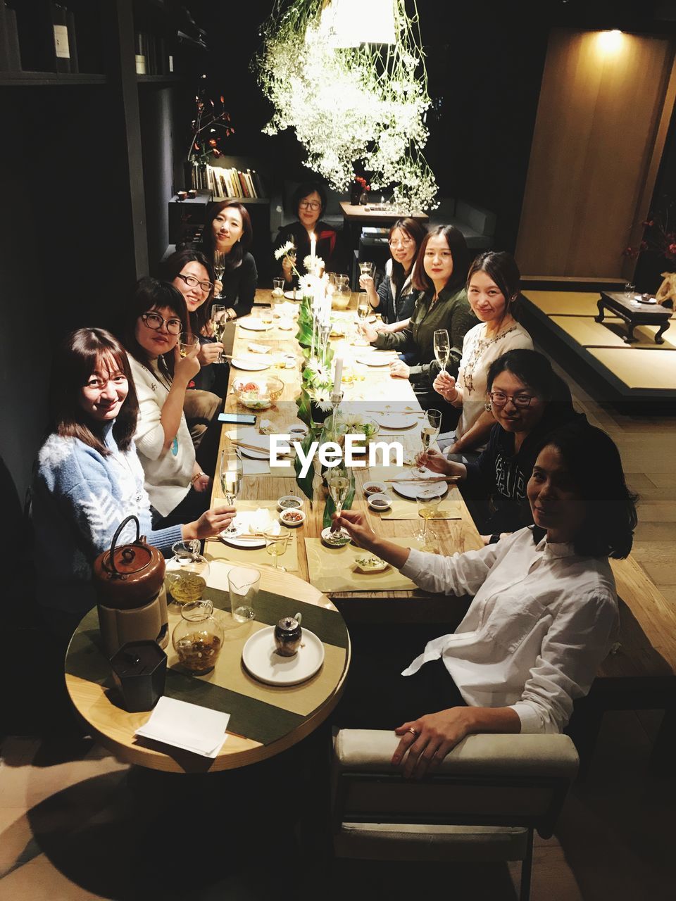 GROUP OF PEOPLE AT TABLE IN RESTAURANT