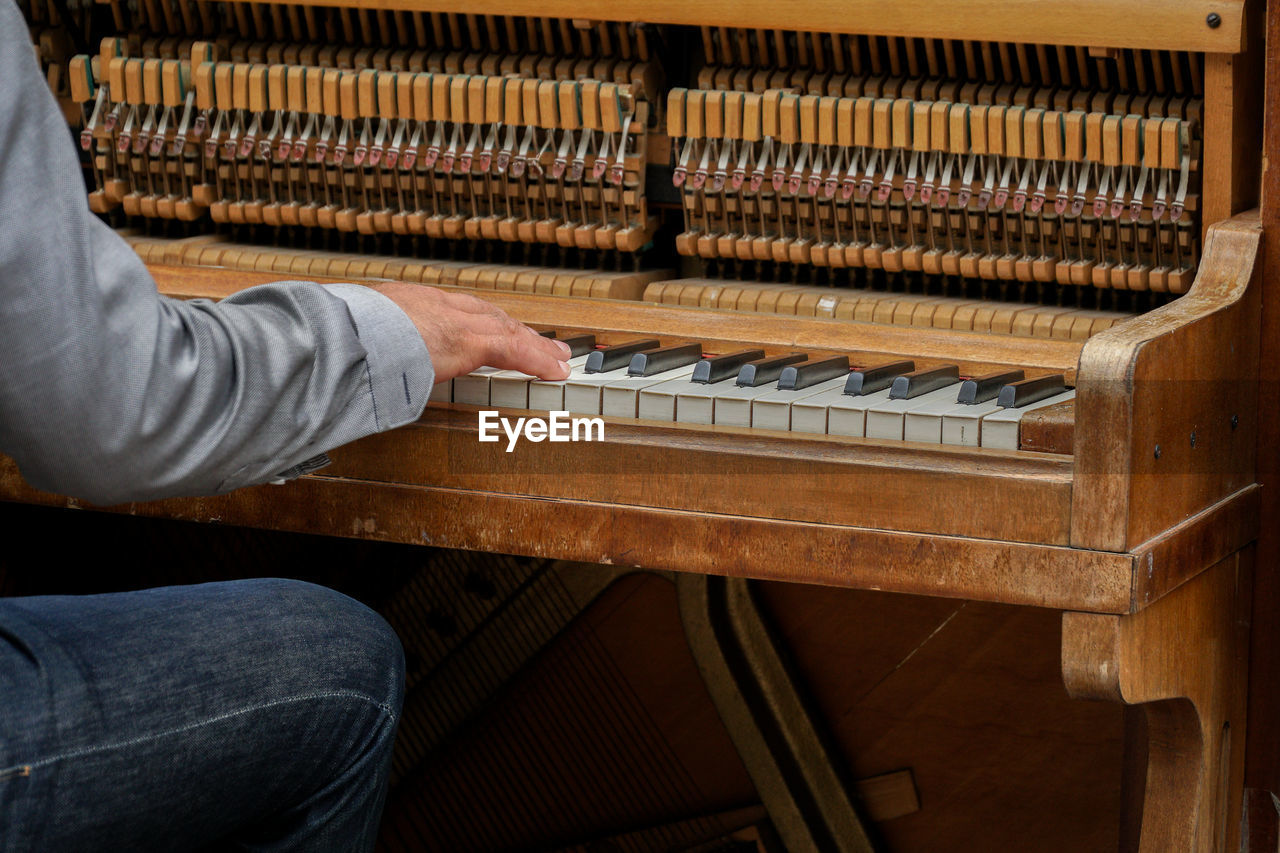 Midsection of man playing piano