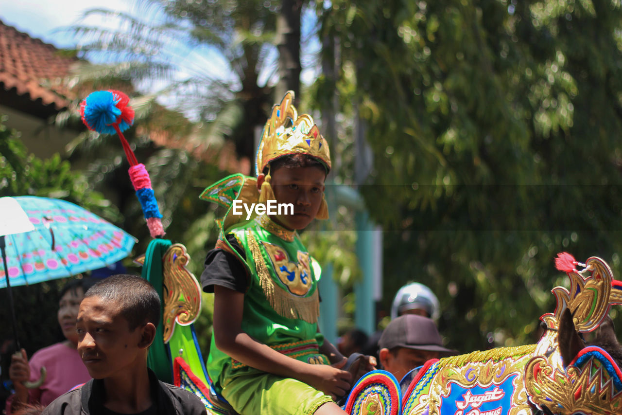 REAR VIEW OF PEOPLE ENJOYING IN TRADITIONAL CLOTHING