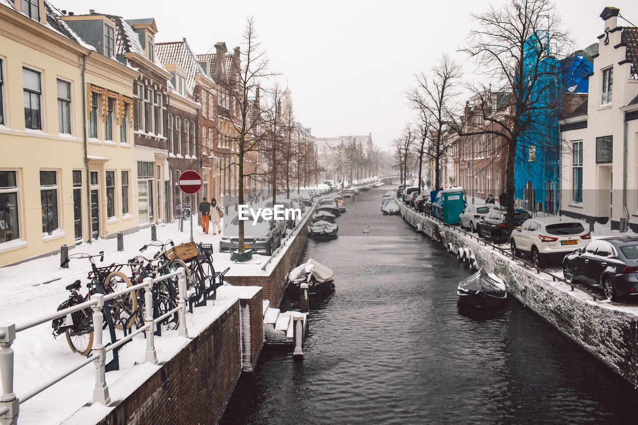 CANAL AMIDST BUILDINGS AGAINST SKY IN CITY