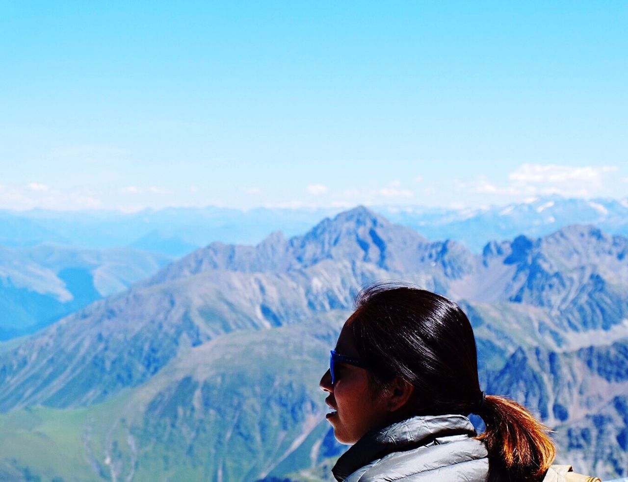 Side view of female hiker on mountain against blue sky