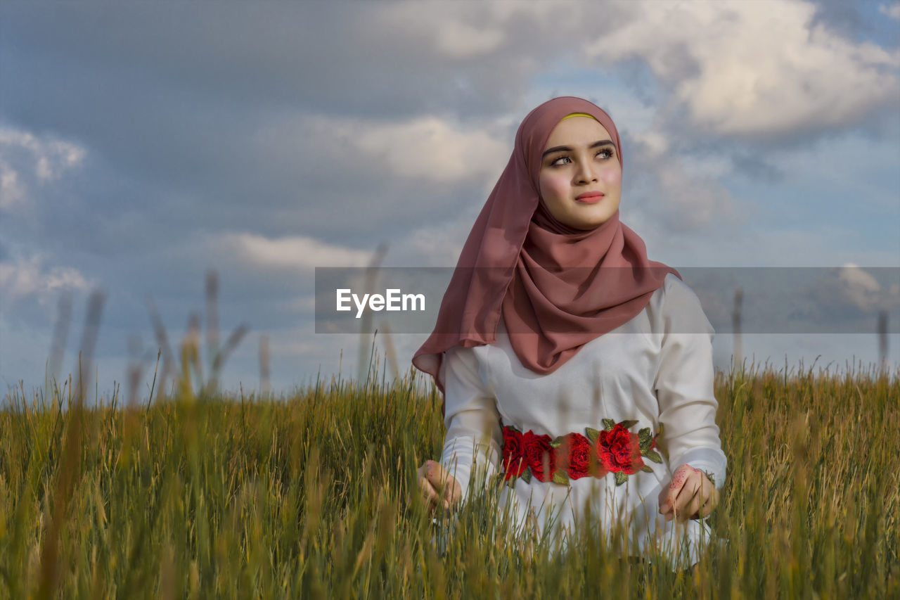 Woman standing on field against sky