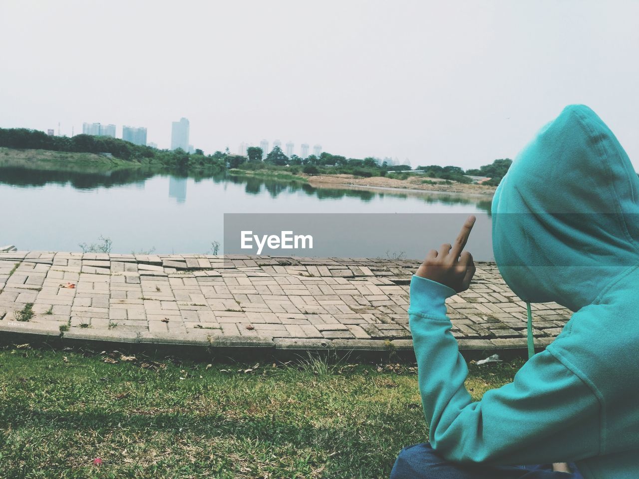 Man showing middle finger by lake