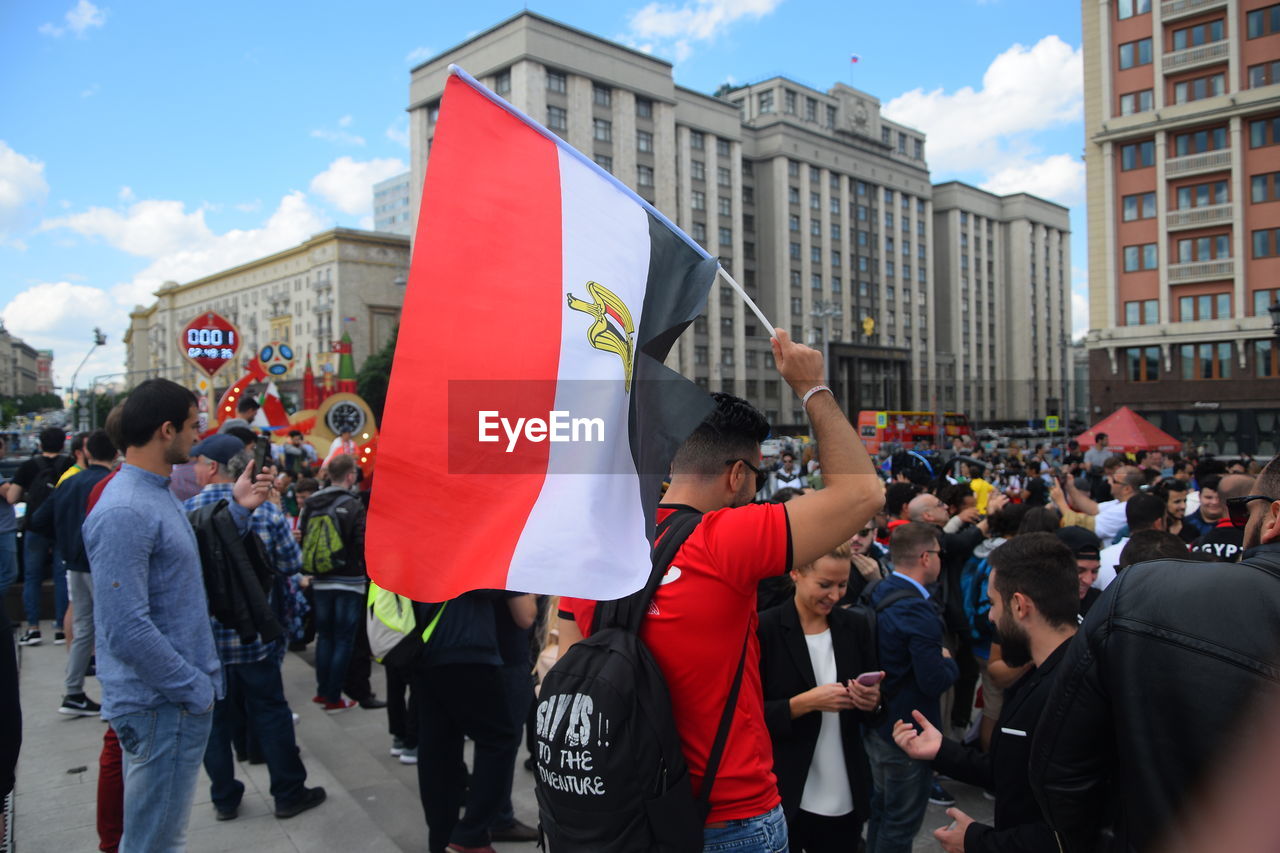People on street against buildings in city