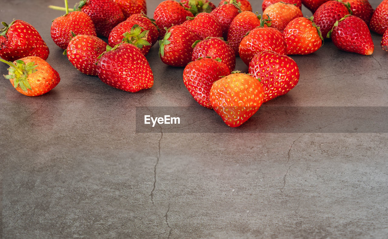 HIGH ANGLE VIEW OF STRAWBERRIES AND FRUITS ON TABLE