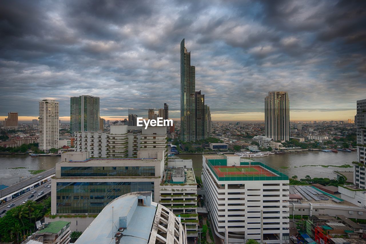 Modern cityscape against cloudy sky