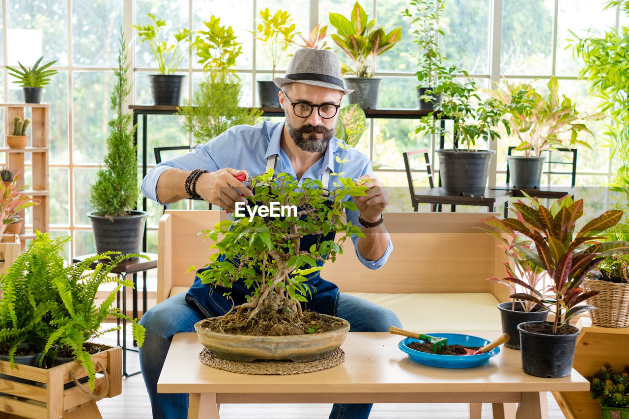 Young man holding potted plant