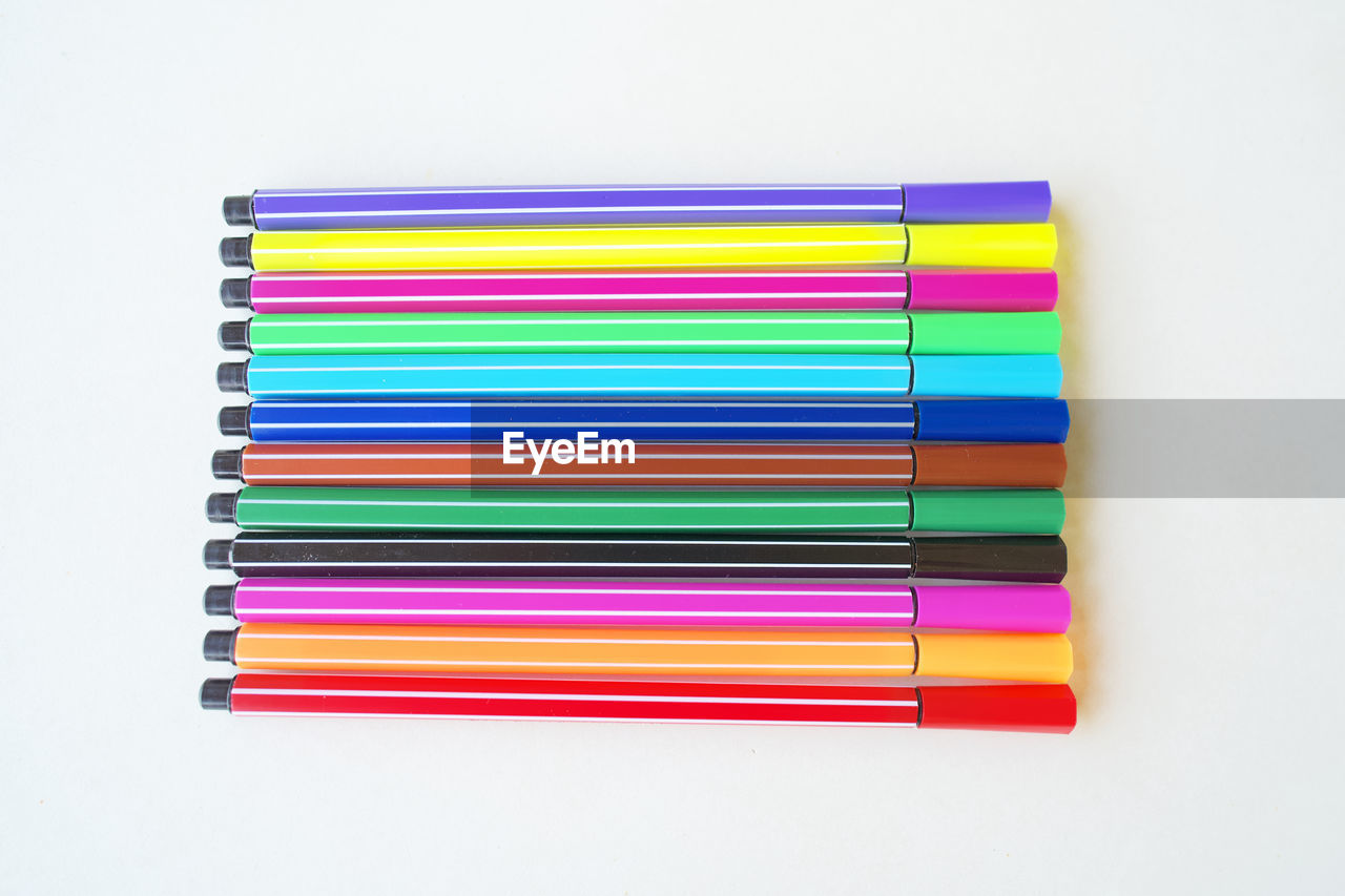 HIGH ANGLE VIEW OF MULTI COLORED PENCILS IN WHITE BACKGROUND