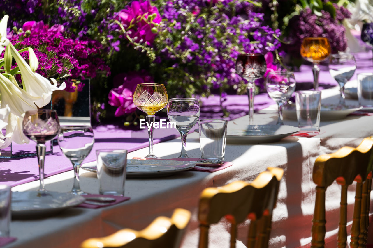 Laid celebration dinner table with empty beautiful tableware for holiday outdoor in summer sun day.