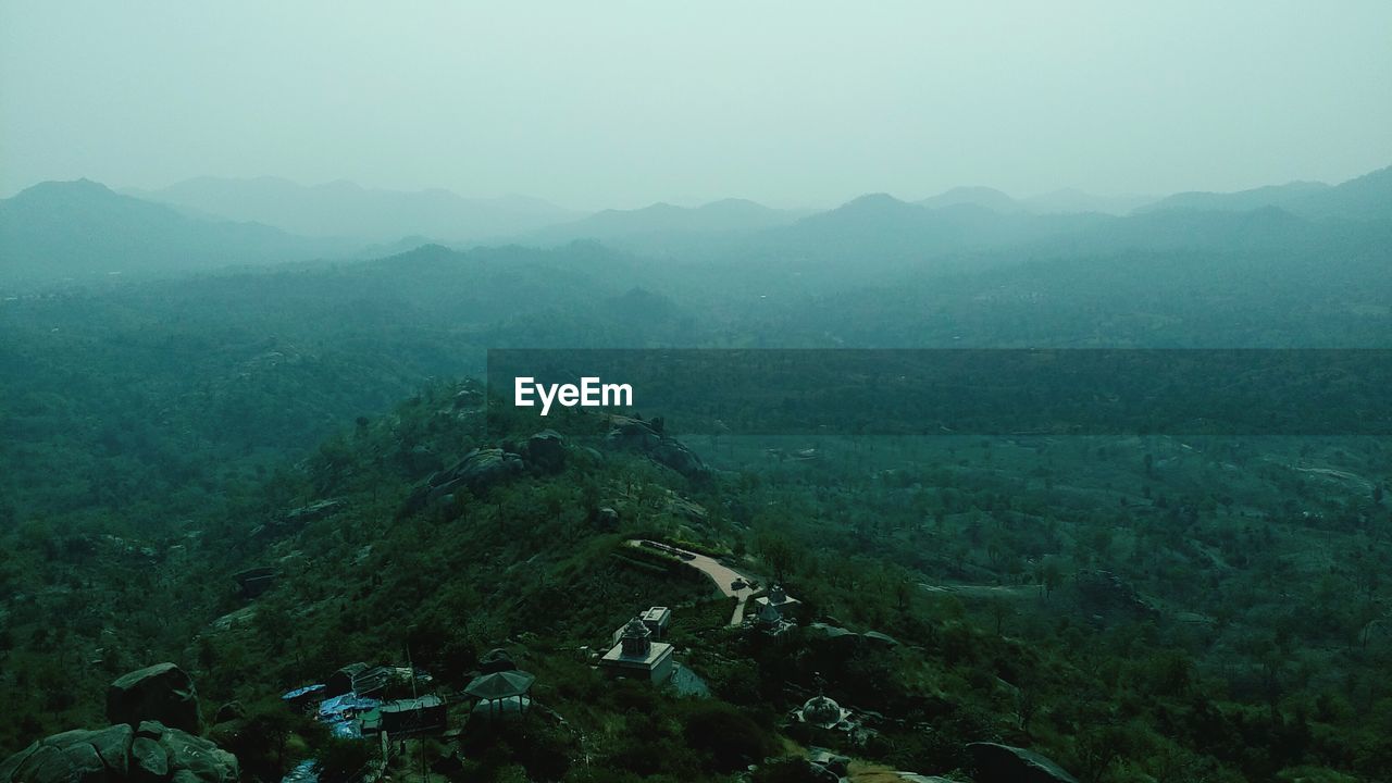 AERIAL VIEW OF TREE MOUNTAINS AGAINST SKY