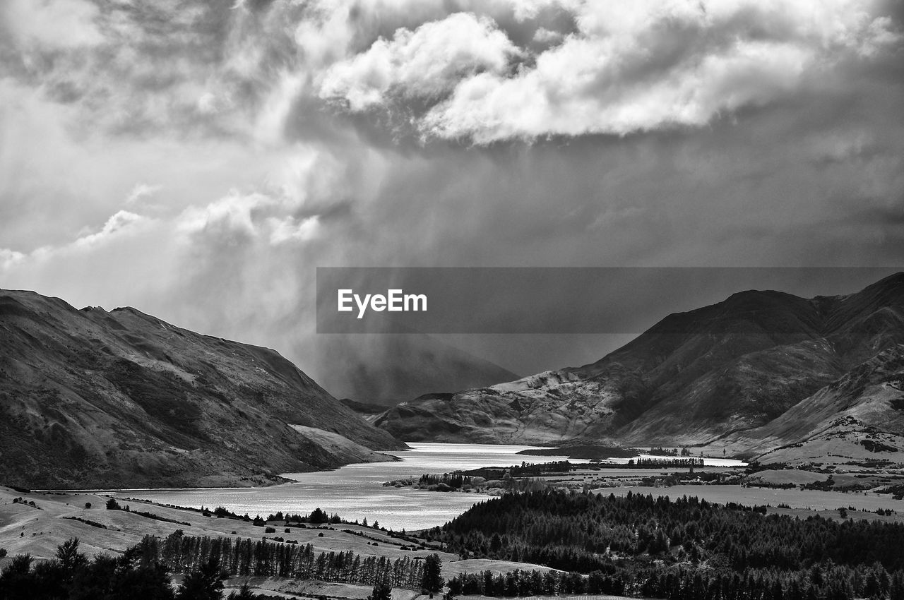 Scenic view of sea and mountains against sky