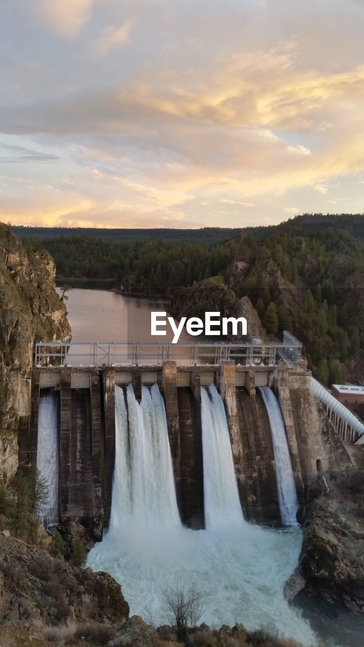 High angle view of long lake dam against sky during sunset