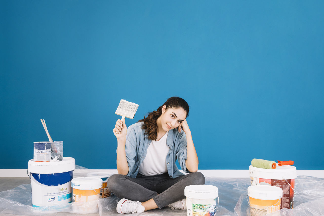 YOUNG WOMAN SITTING ON TABLE WITH BLUE UMBRELLA