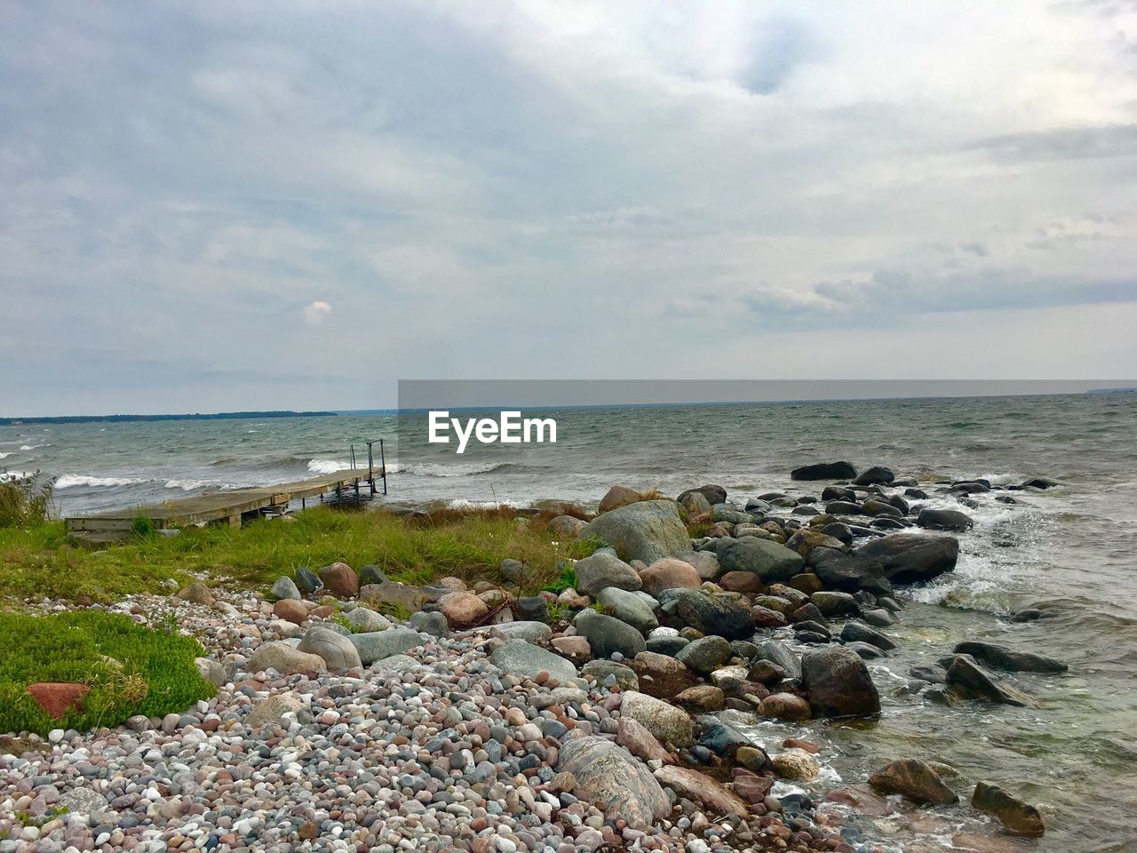 VIEW OF PEBBLES ON BEACH AGAINST SKY