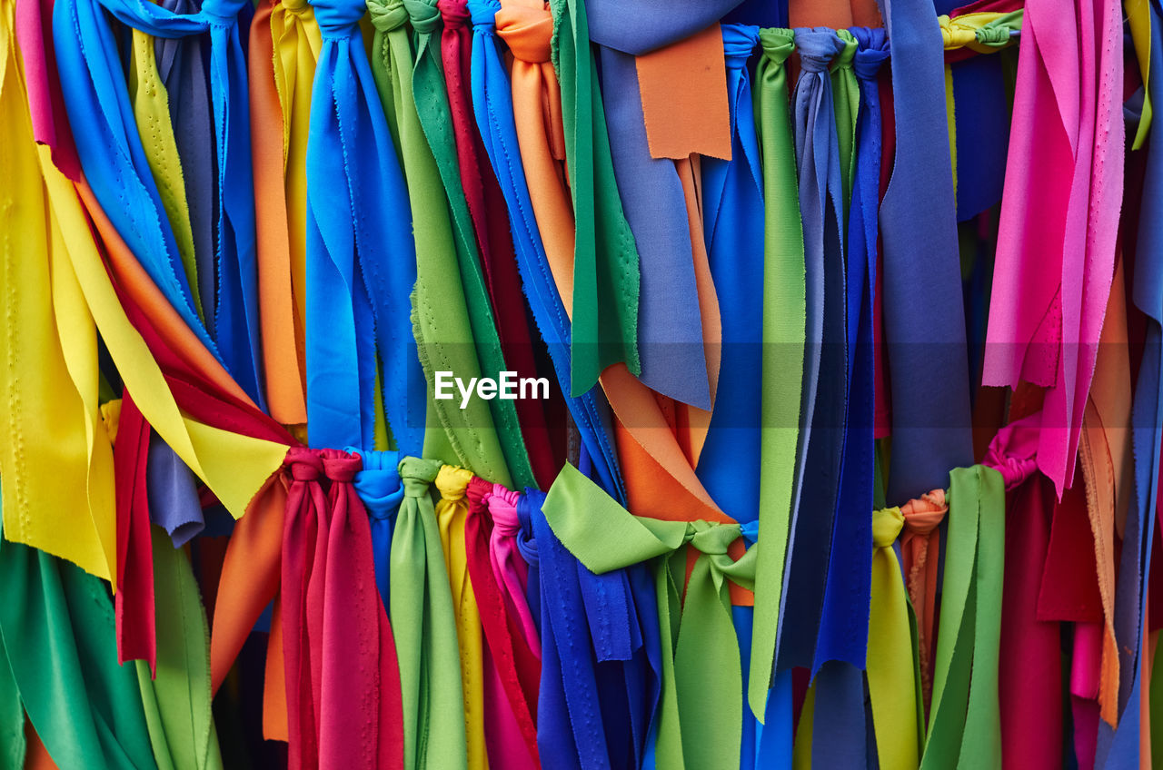 multi colored, clothing, hanging, variation, retail, full frame, large group of objects, no people, blue, backgrounds, textile, for sale, market, in a row, side by side, fashion, store, abundance, business, day, sale, shopping, close-up, yellow