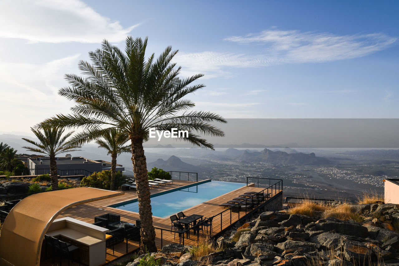 HIGH ANGLE VIEW OF PALM TREE BY SEA AGAINST SKY