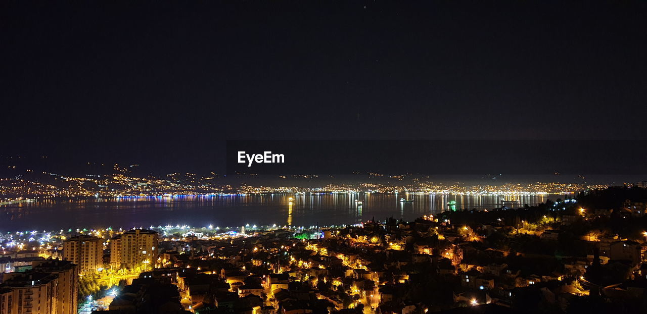 HIGH ANGLE VIEW OF ILLUMINATED CITY AT NIGHT