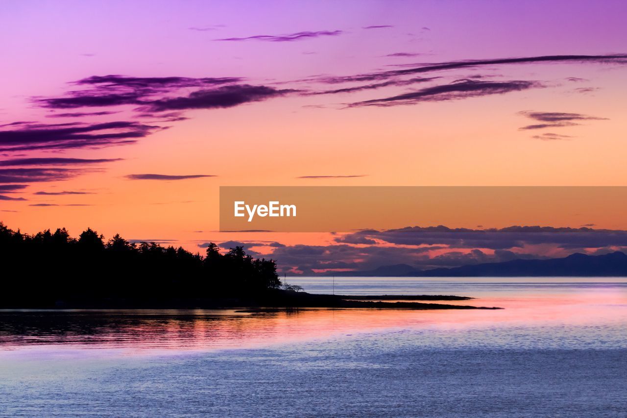 SCENIC VIEW OF BEACH AGAINST SKY DURING SUNSET