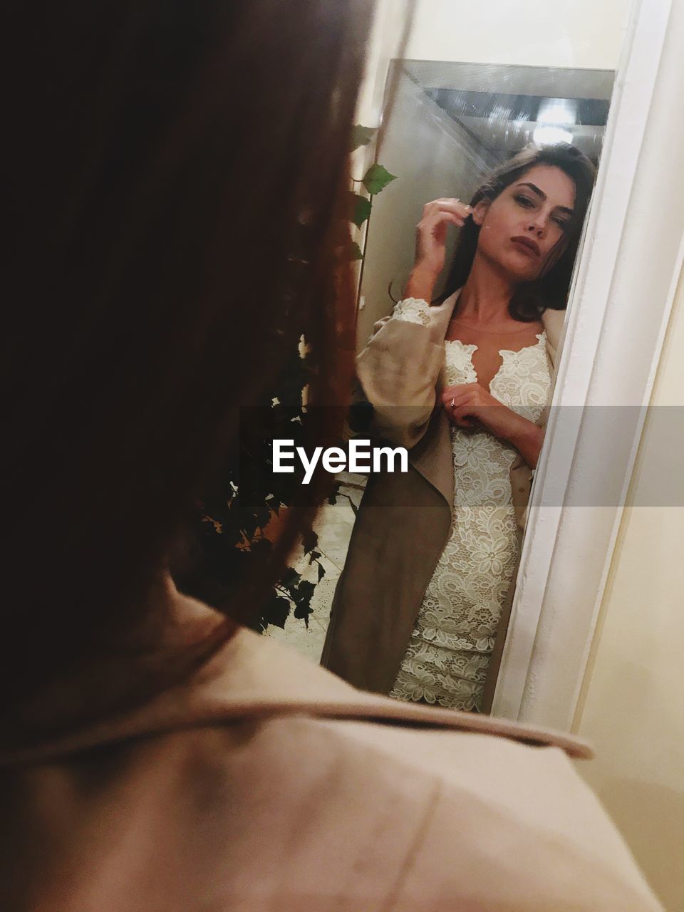 Young woman standing in front of mirror