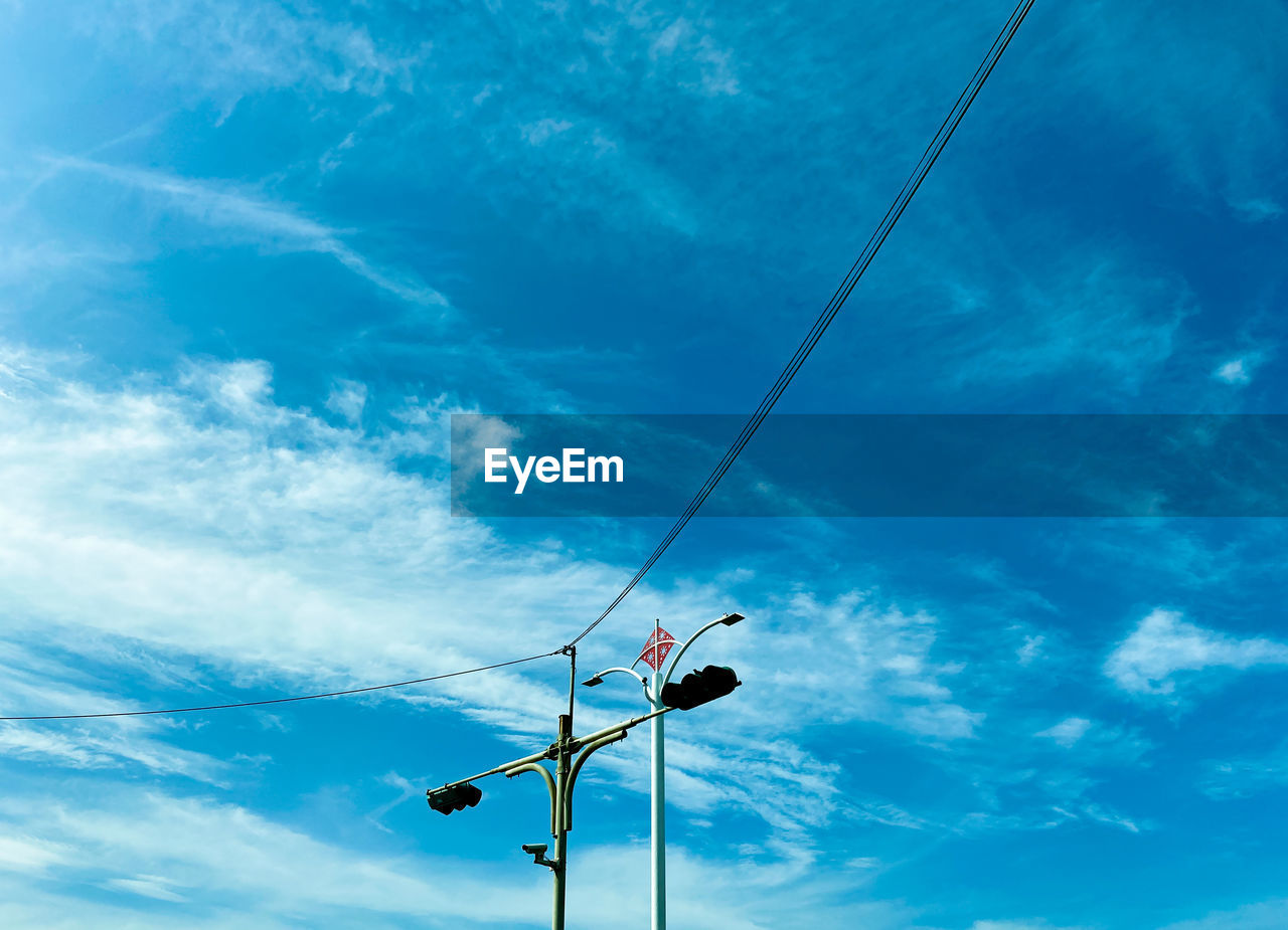 Low angle view of street light against blue sky