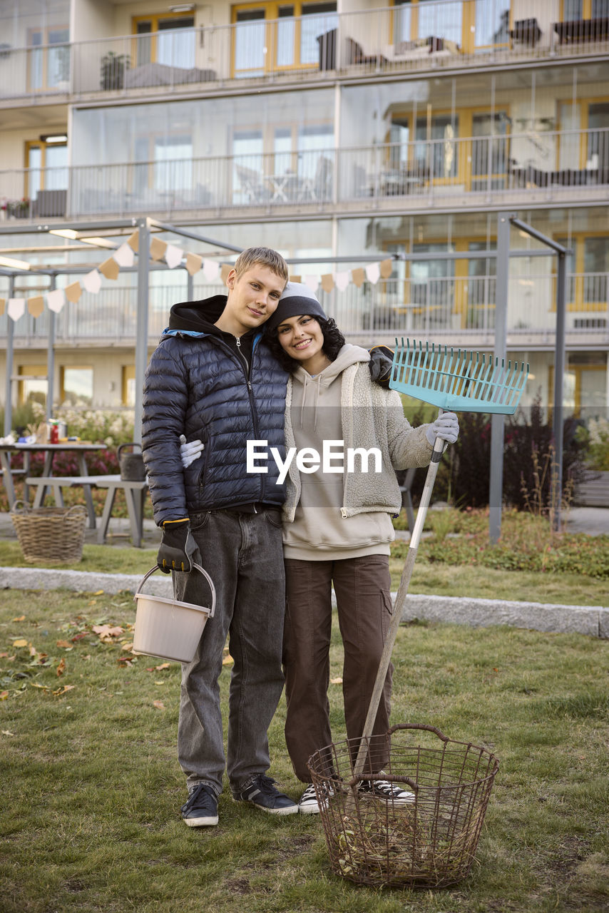 Young people holding garden tools