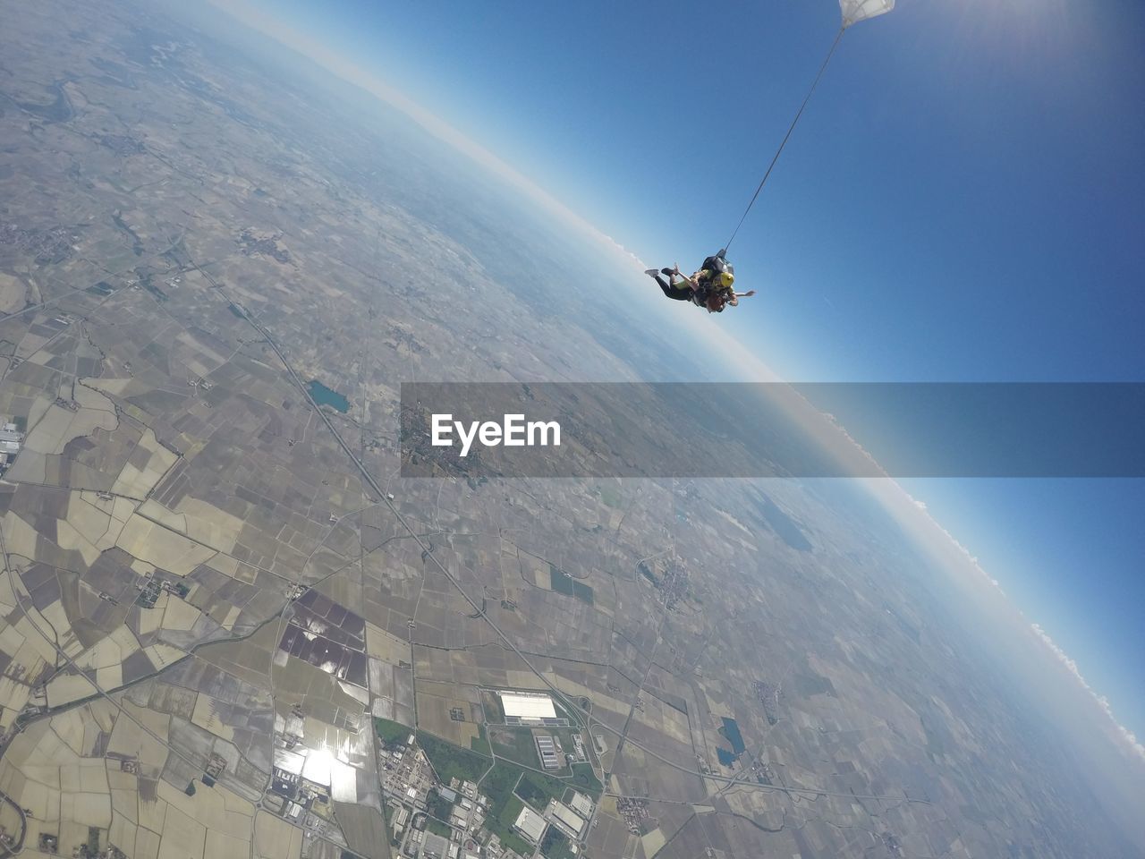 Couple skydiving in italy, looking at the horizon from  above 